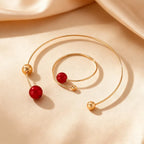 Gold-tone collar and bracelet set with red pearl beads and round ball connectors