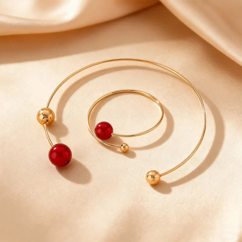 Gold-tone collar and bracelet set with red pearl beads and round ball connectors