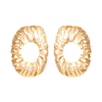 Textured gold oval stud earrings with ridged hammered pattern and hollow center