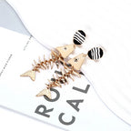 Gold-tone fishbone dangle earrings set with black-and-white striped round tops
