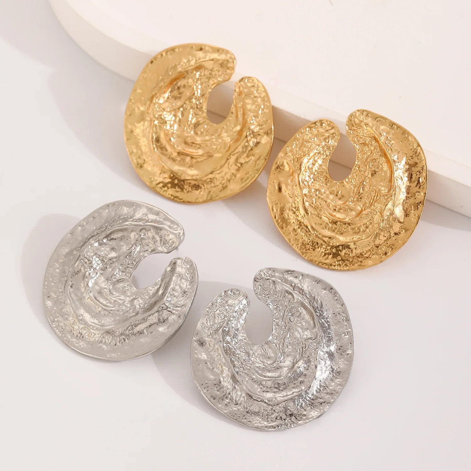 Textured crescent drop earrings in gold and silver, hollow center design