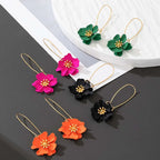 Floral stud earrings in pink, black, green, and orange with gold-tone hooks