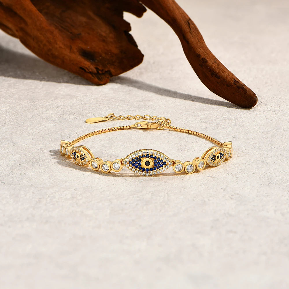 Gold-tone evil eye bracelet with blue oval center and round crystal pavé links