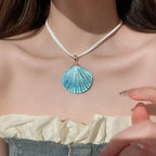 Shell pendant necklace with gold starfish detail and blue scallop shell drop