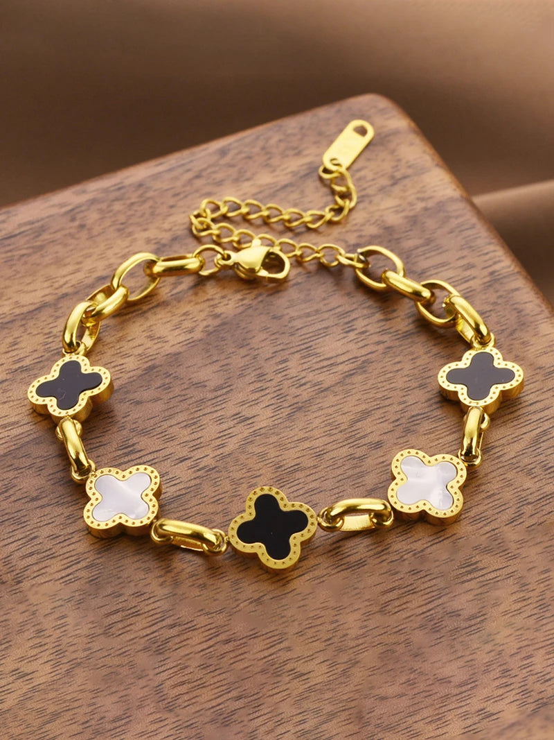 Four-leaf clover charm bracelet with gold-tone chain and white enamel clover charms