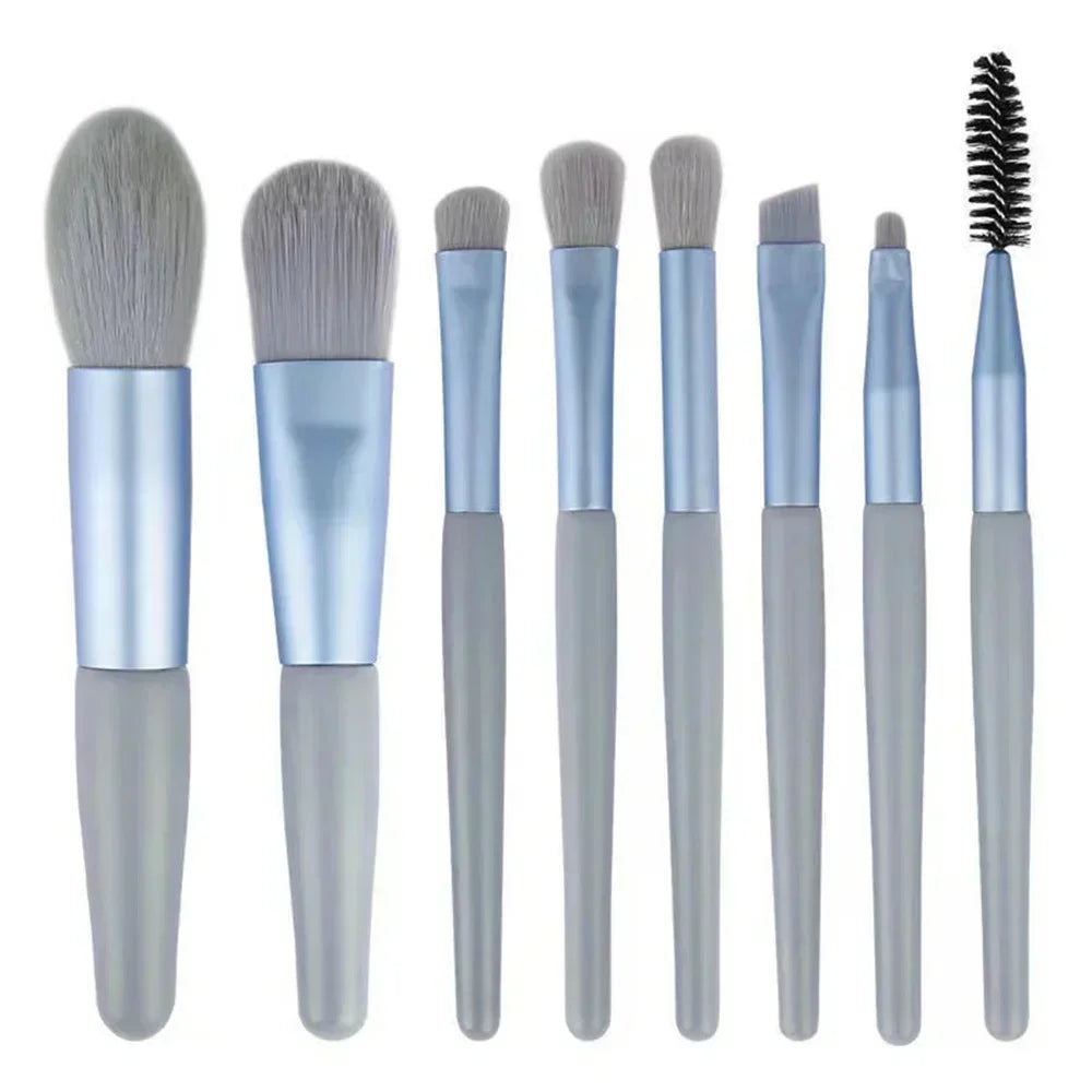 Makeup brush set with light blue handles and soft gray bristles; includes black spoolie