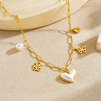 Gold-tone pendant necklace with pearl drop, heart charm, butterfly link, flower charm