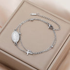 Silver-tone oval pendant bracelet with Virgin Mary medallion and cross charm on chain