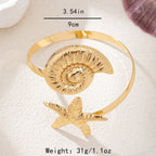 Gold open cuff arm ring with textured round shell disk and starfish charm