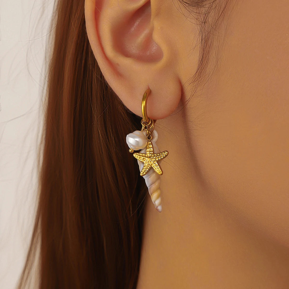 Gold starfish charm conch-and-pearl drop earrings in hoop style