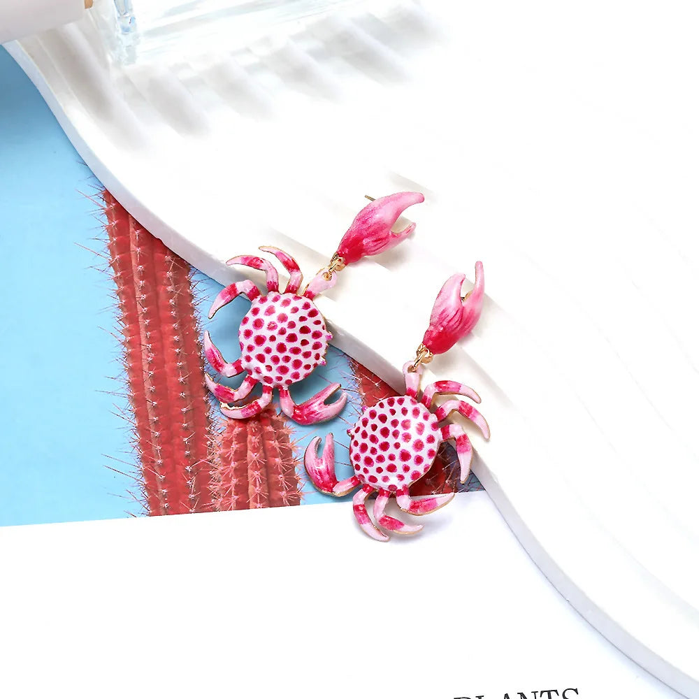 Crab drop earrings with red-and-white dotted bodies, pink claws, and gold hooks