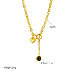 Gold-tone chain necklace with heart charm and round black stone pendant