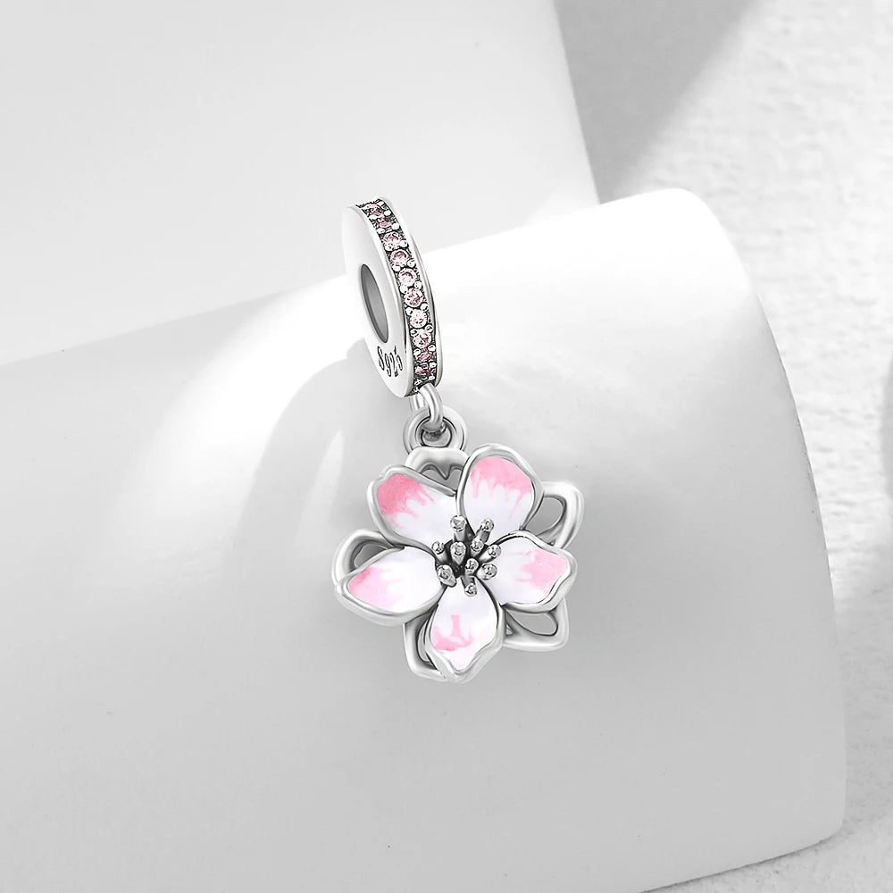 Silver-tone charm bead with a pink flower pendant and small clear stone accents