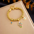 Gold-tone beaded charm bracelet with hamsa pendant and blue eye bead charms