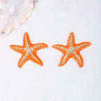 Starfish stud earrings, orange starfish with silver-tone texture, close pair view