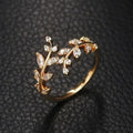 Gold-tone adjustable ring with leafy floral design and clear sparkling stones