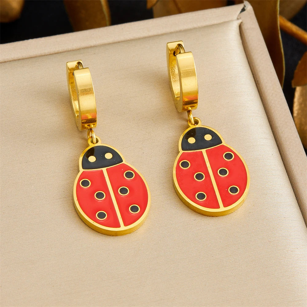 Gold tone hoop earrings with ladybug drop charms