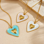 Two enamel heart pendants on gold chains: blue and white with gold inner hearts