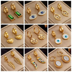 Gold hoop earring set with assorted enamel charms including heart and eye styles