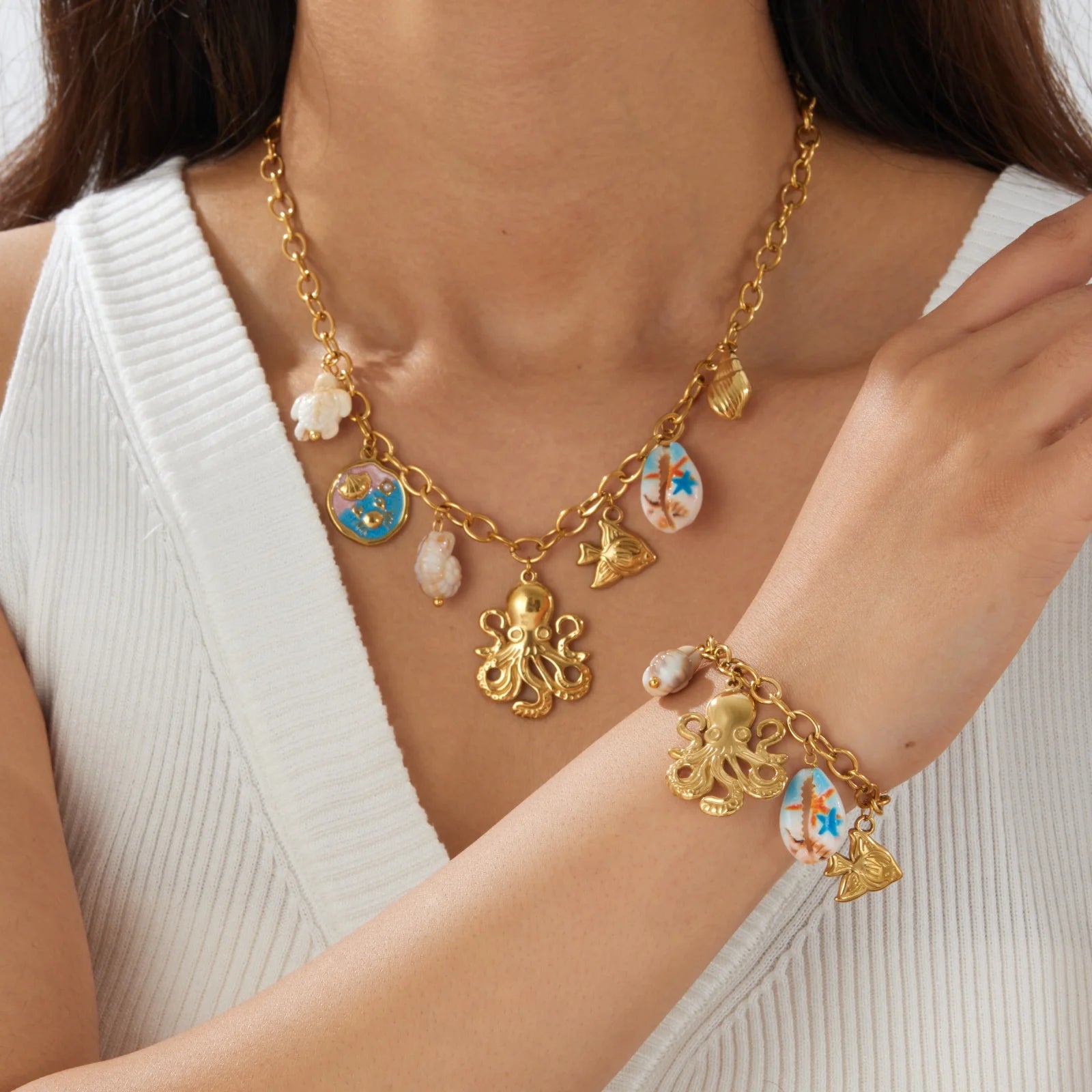 Gold-tone shell charm necklace with octopus pendant, butterfly and fish enamel drops.