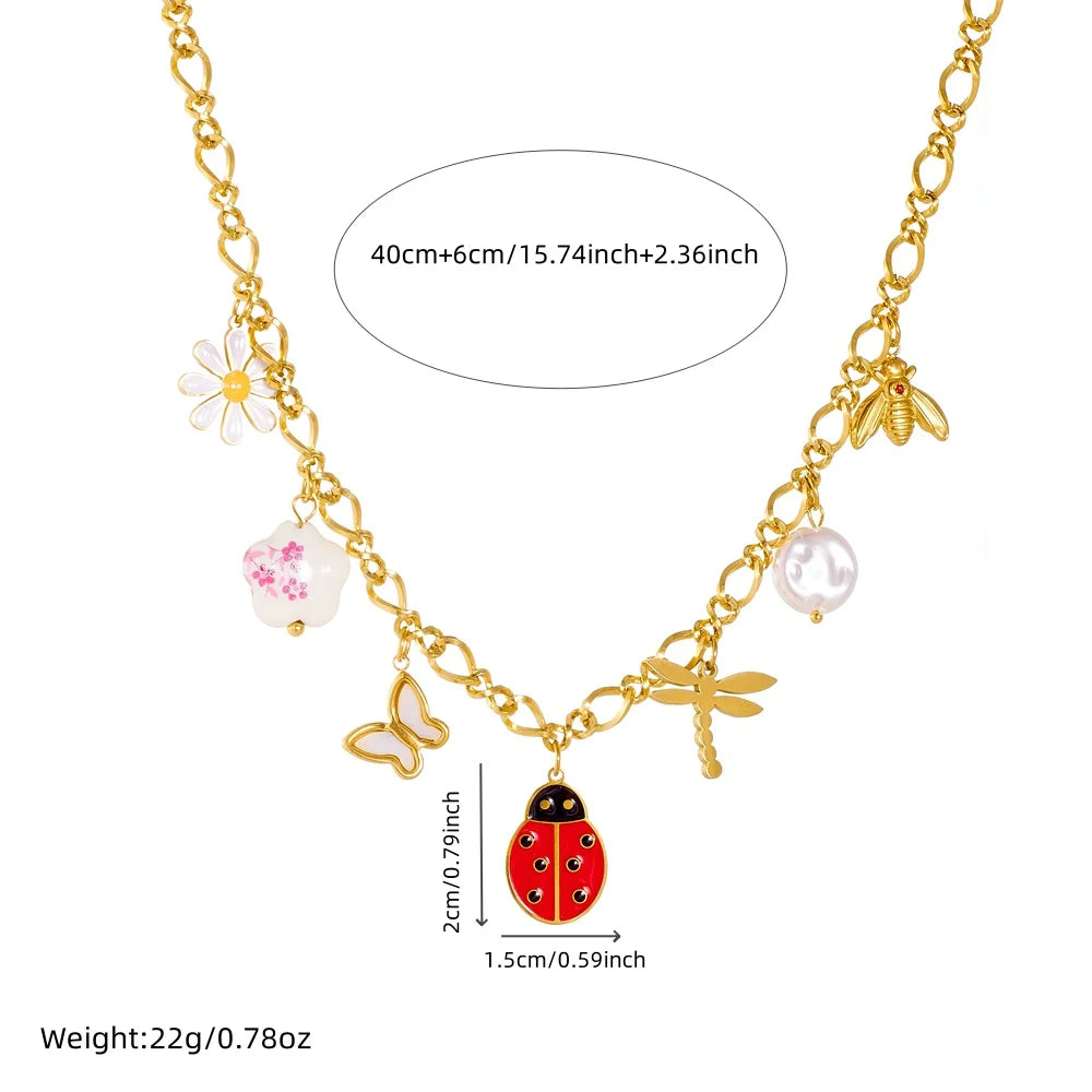 Gold-tone ladybug charm necklace with flower and pearl drop details; length-mark diagram