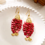 Pair of red bead koi charm earrings with gold-tone tops and fish-tail dangles.
