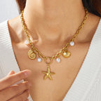 Gold-plated pendant necklace with starfish, shell charm, and white pearl bead accents on chain