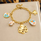 Gold-tone shell charm bracelet with octopus pendant and blue enamel shell and bow charms.