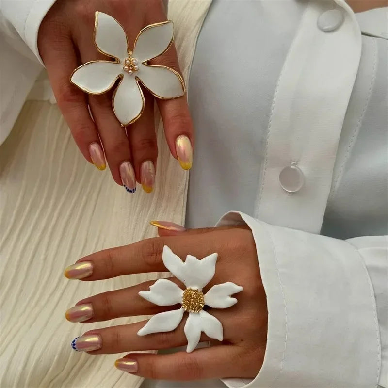 Adjustable flower ring with white petals and gold-toned center, open band design
