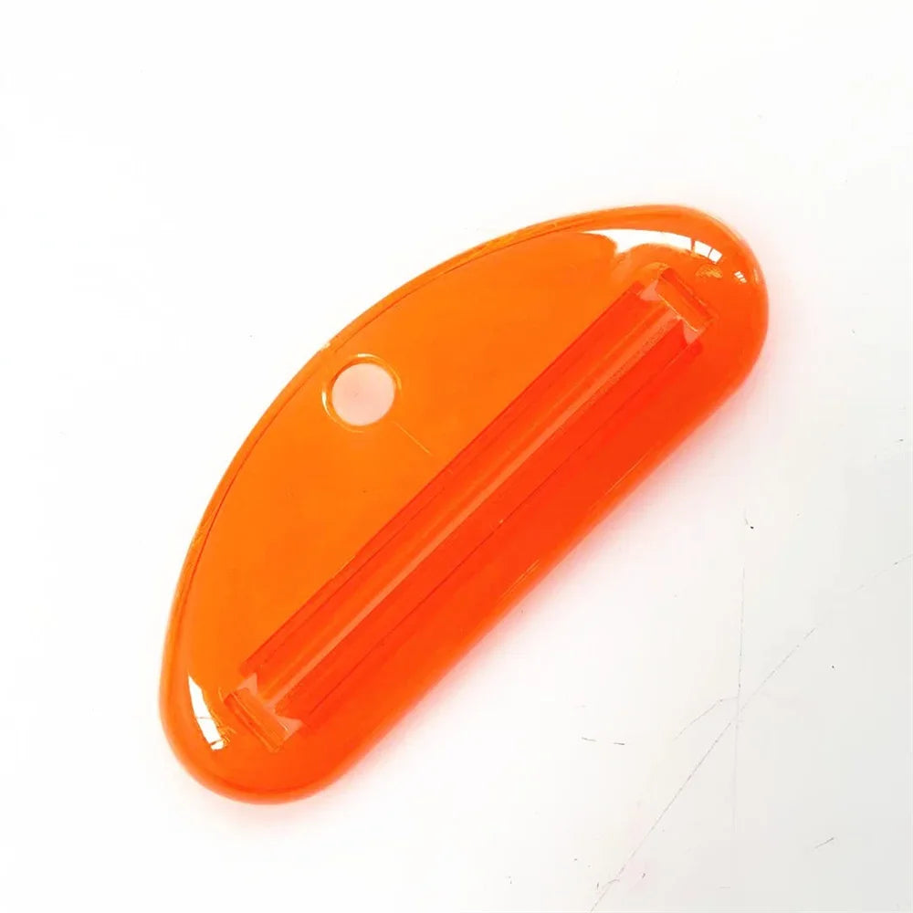 Toothpaste tube squeezer dispenser, orange oval with ridged squeeze slot