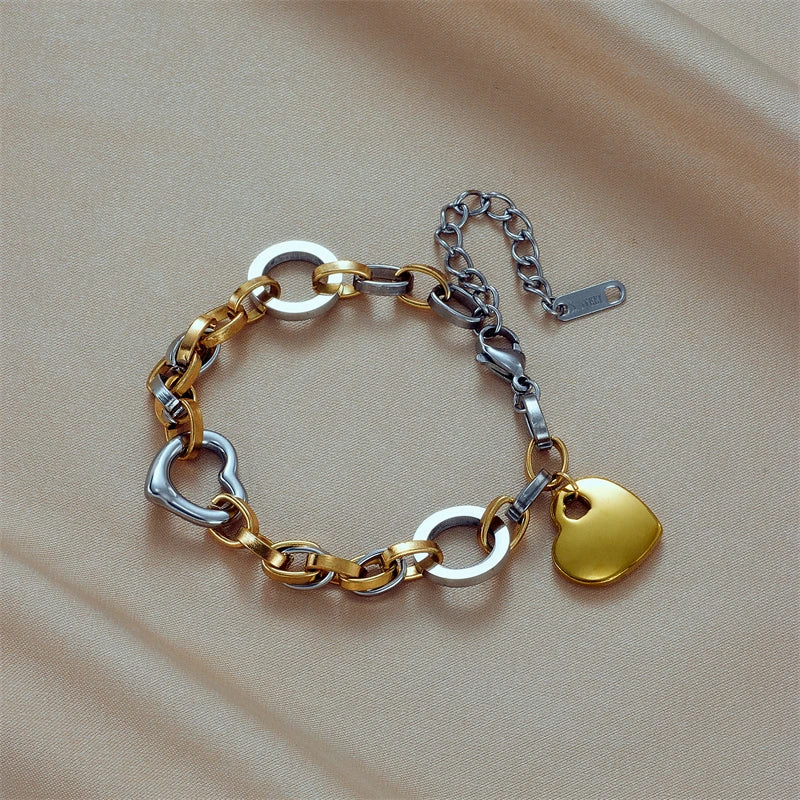 Two-tone chain bracelet with gold heart charm, silver heart links, and extender clip
