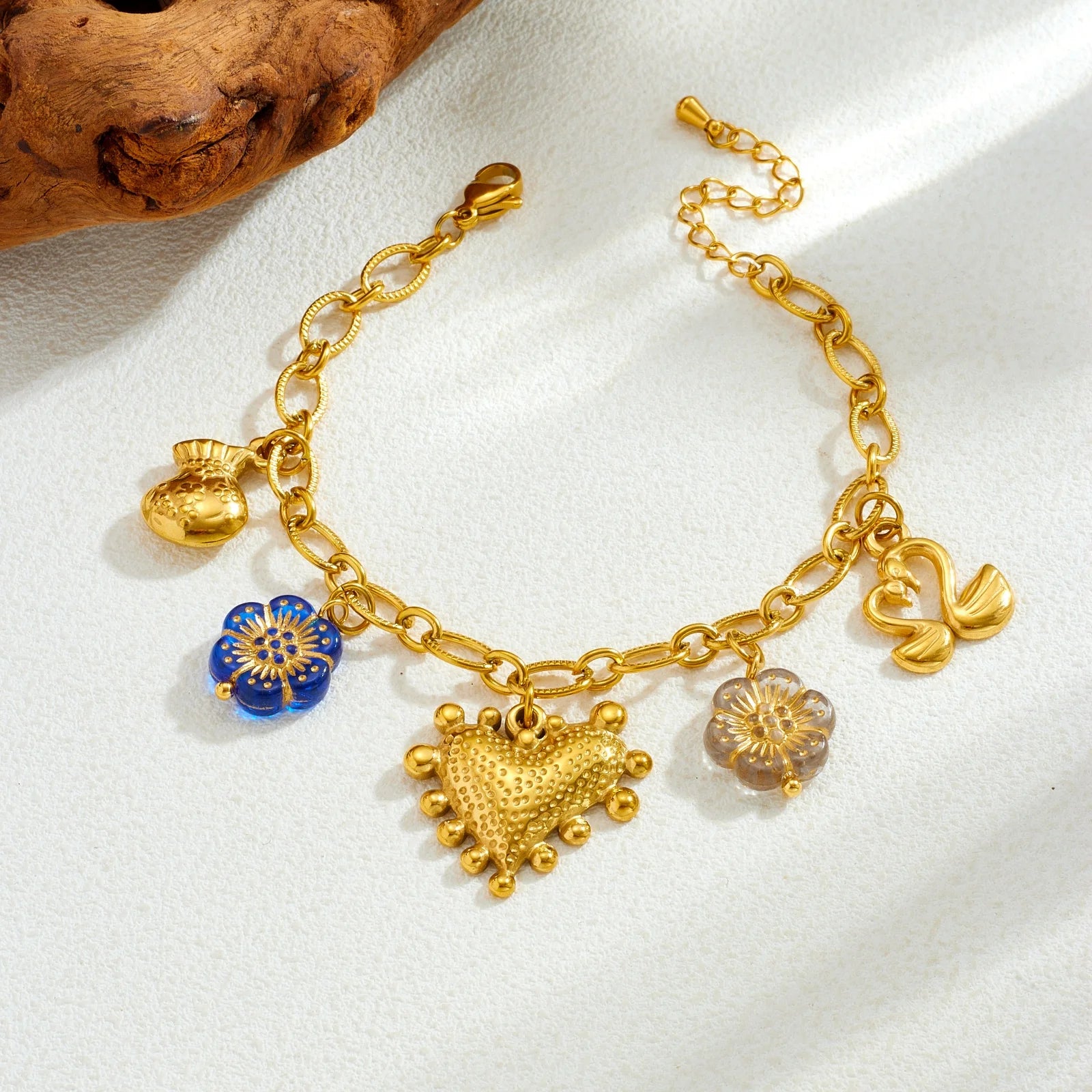 Gold-tone multi-pendant bracelet-style necklace with blue flower charm and heart center charm