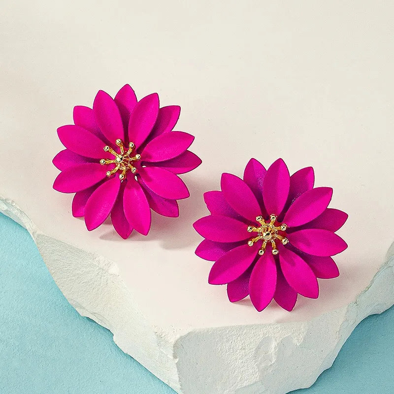 Pink enamel flower stud earrings with gold-tone starburst centers