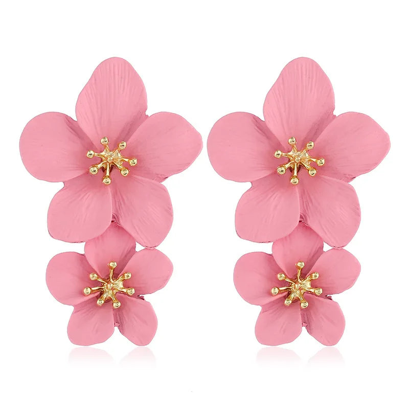 Pink double-flower dangle earrings with gold-tone star accents