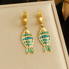 Fish enamel huggie hoop earrings, gold-tone with striped teal and blue fish charms
