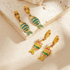 Fish enamel huggie hoop earrings, gold-tone with mixed red and teal striped fish charms