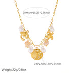 Gold-tone ocean charm necklace with pearl drops and crab, turtle, scallop shell pendants