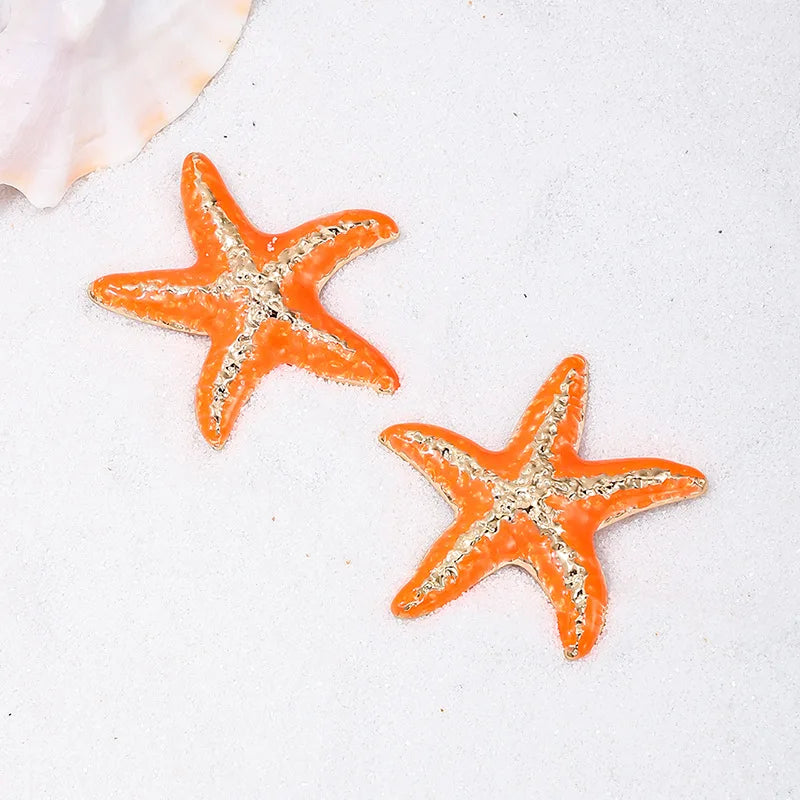 Starfish stud earrings with orange enamel starfish, silver-toned textured edges