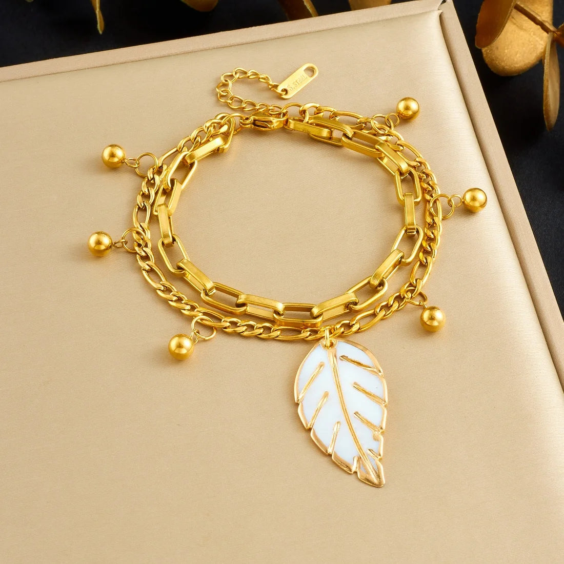 Gold double-layer chain bracelet with leaf pendant and round bead accents