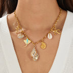 Gold-tone multi-pendant ocean necklace with starfish, seashells, and seahorse charms