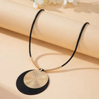 Round dangle earring with black textured disc and gold-tone layered disc