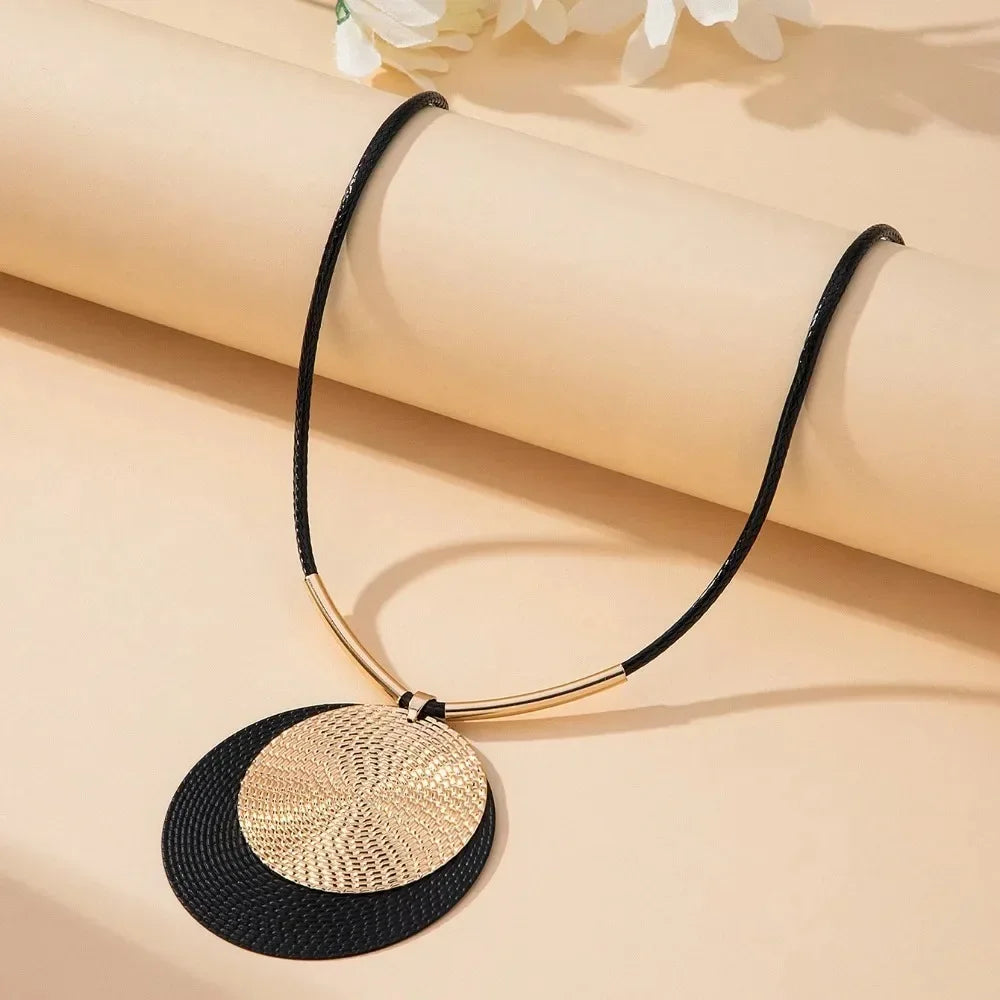Round dangle earring with black textured disc and gold-tone layered disc