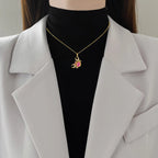 Gold-tone crab pendant necklace with pink rhinestone accents and round center stone.