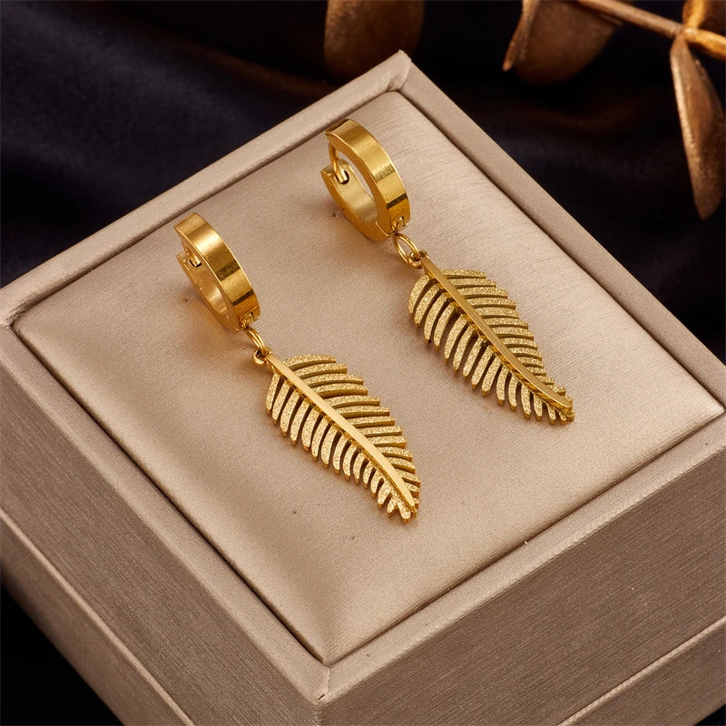 Gold-tone hoop earrings with gold feather charm drops