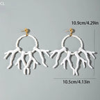White acrylic drop earrings with beaded hoops and dangling coral-like fringe