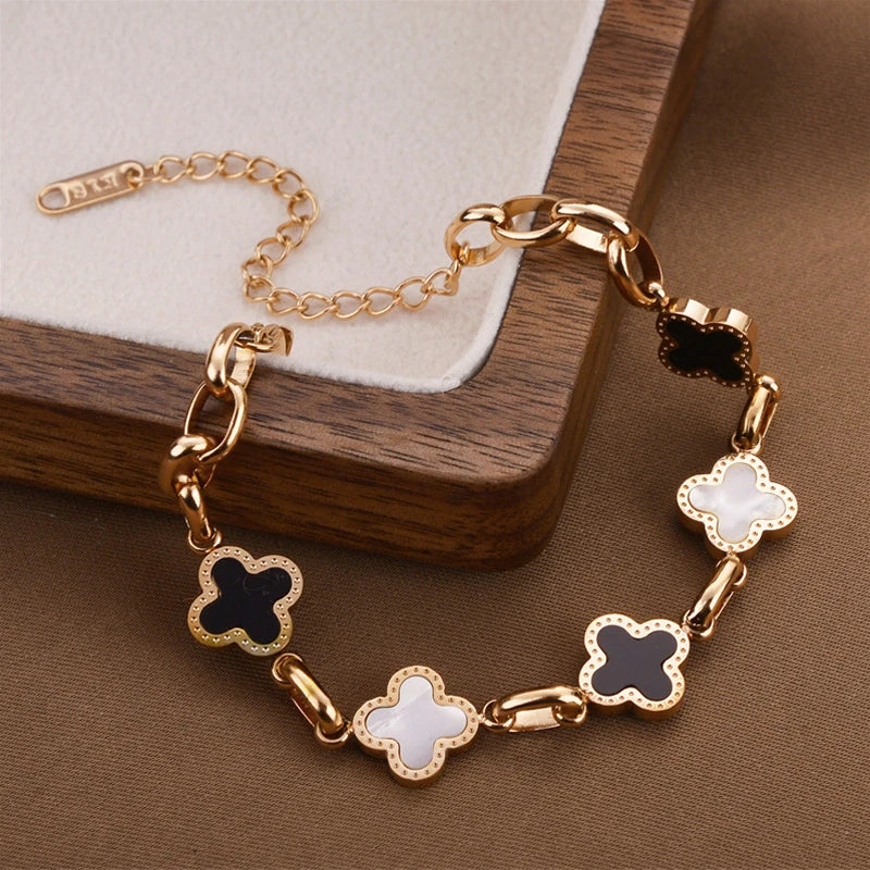 Rose-gold tone clover charm bracelet with dark and white enamel four-leaf charms