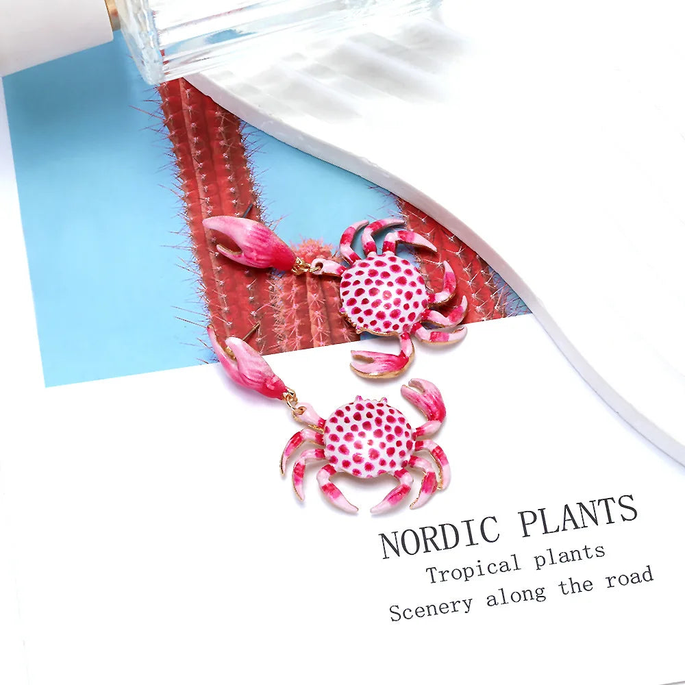 Crab enamel earrings with red-and-white dotted crabs, pink claws, and gold hooks