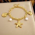Gold-tone charm necklace with seashell and pearl drops, featuring a starfish pendant