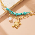Gold double-layer necklace with turquoise beads and pearl plus turtle charm, close view