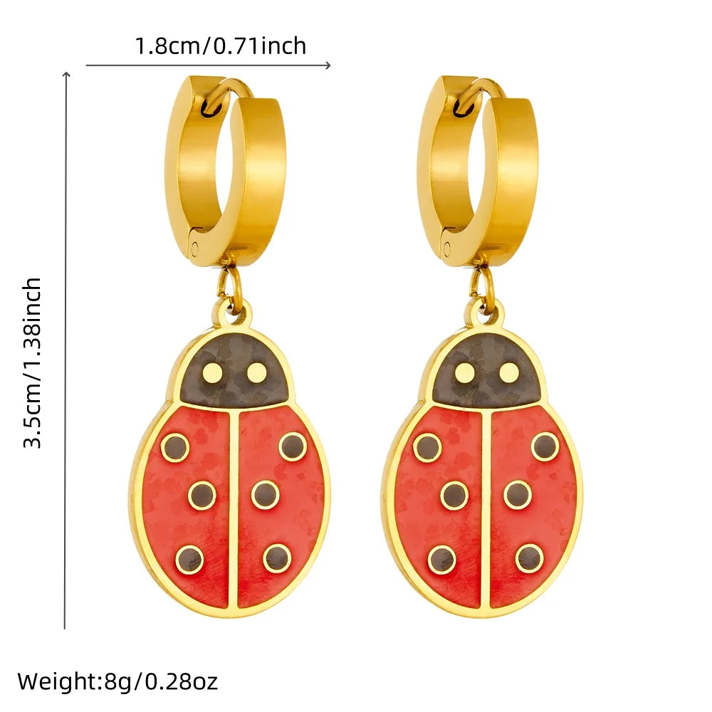 Gold-tone ladybug drop hoop earrings with red enamel body and black accents; size-mark diagram